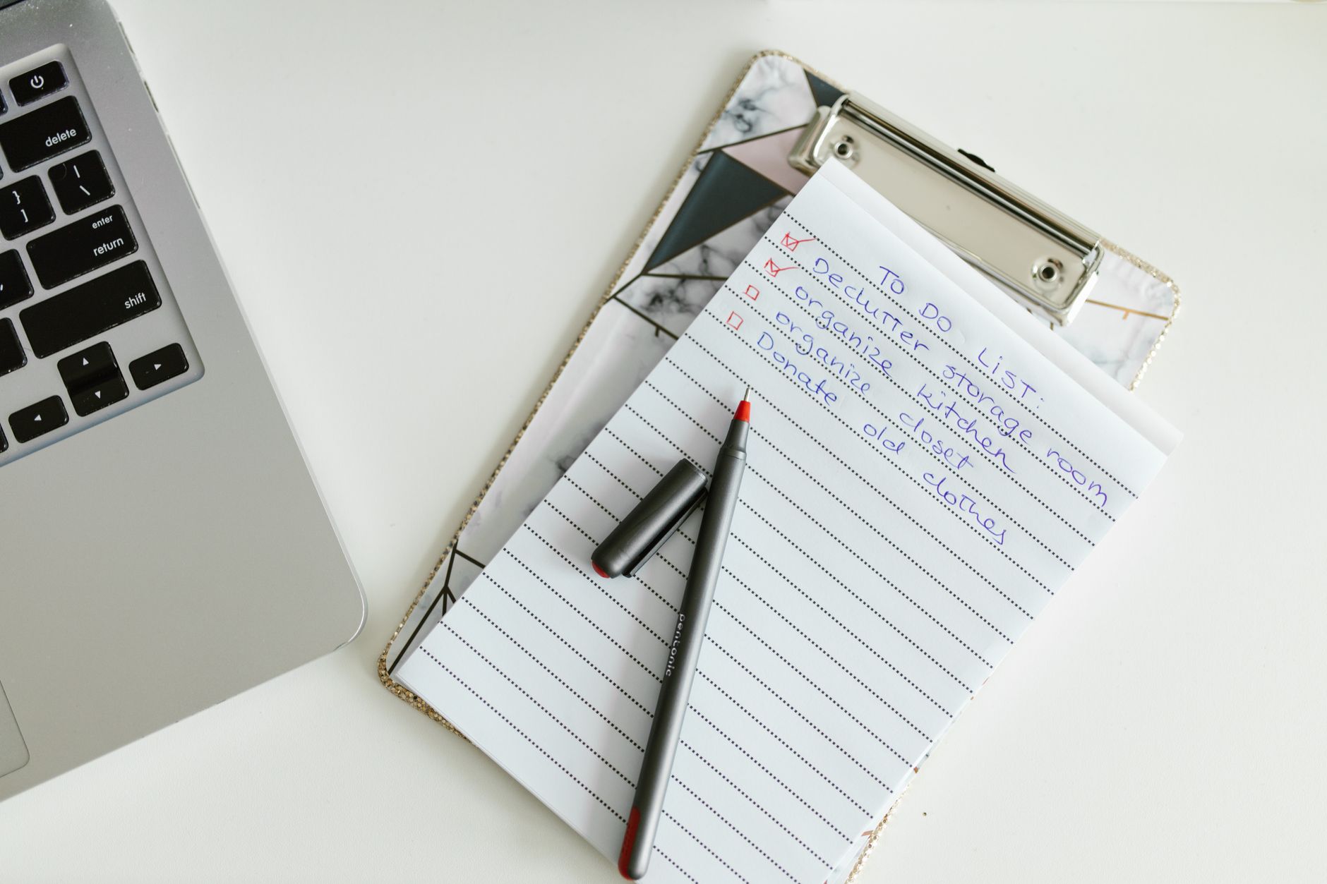 A neatly organized to-do checklist on a clipboard next to a laptop